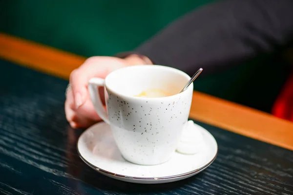 Weiße Tasse Kaffee Auf Einem Tisch Vor Verschwommenem Grünem Hintergrund — Stockfoto