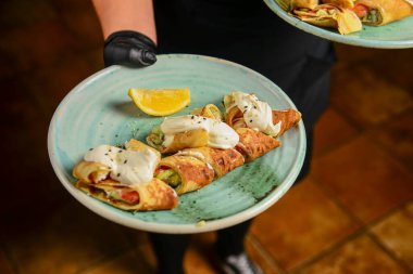 Lokantada ya da lokantada garson tarafından ekşi kremayla servis edilen etli ve sebzeli krep ruloları. Ukrayna mutfağı kavramını tüketiyor..