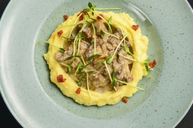 Siyah arka planda servis edilen mantar soslu patates püresini kapat. Sağlıklı gıda konsepti.