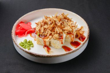 Soya ve wasabi soslu suşi. Siyah arka planda beyaz tabakta servis edilmiş. Japon mutfağı kavramı.