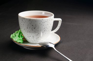 Siyah arka planda beyaz çay fincanı. Çay saati yakın..