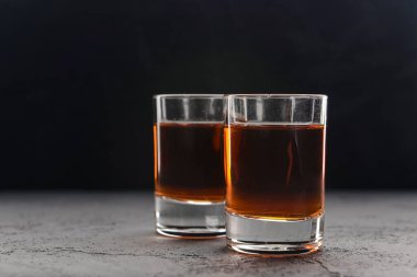 Siyah arka planda alkollü iki kadeh. Alkollü içecekler, içkiler. Boşluk afişini kopyala.