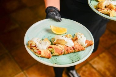 Lokantada ya da lokantada garson tarafından ekşi kremayla servis edilen etli ve sebzeli krep ruloları. Ukrayna mutfağı kavramını tüketiyor..