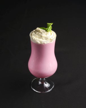 Siyah arka planda kokteyl bardağında çilekli smoothie. Lezzetli yaz soğuk kokteyli. Meyveler yakın..