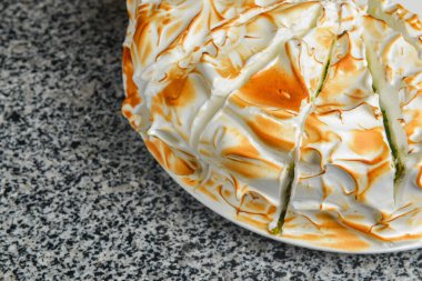 Üstünde krem şanti olan kibrit keki. Çay ya da kahve saati için lezzetli tatlı pasta. Gri desenli masada servis edilir..,