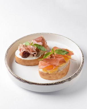 Sulu domates ve taze ekmek üzerine carpaccio eti ile taze meyve, üzerine sos. Geleneksel İtalyan mutfağı. Beyaz arkaplan üzerinde beyaz plaka.