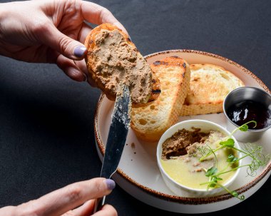 Ezme ve reçelli kızarmış ekmek. Et ezmeli ve meyve reçelli lezzetli sandviç. Kızarmış ekmeğin üzerine börek koyuyorum. Siyah arkaplan.