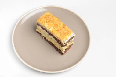 Ekşi kremalı katmanlı bir pasta. Geleneksel Smetannik tarifi, tatlı kremalı pasta. Beyaz arkaplanda yuvarlak bir tabakta servis edilir.