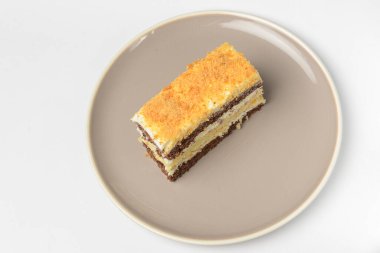 Ekşi kremalı katmanlı bir pasta. Geleneksel Smetannik tarifi, tatlı kremalı pasta. Beyaz arkaplanda yuvarlak bir tabakta servis edilir.