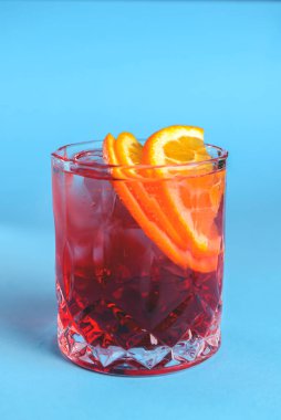 Alkol kokteyli koleksiyonu Negroni. Geleneksel alkollü içecek tarifi. Pastel mavi arkaplanda servis edilir.