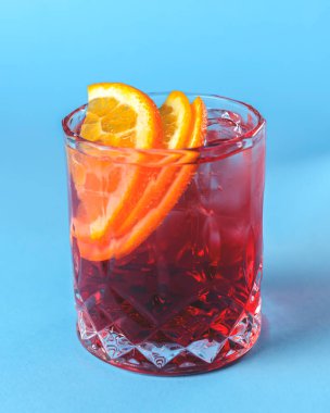 Alkol kokteyli koleksiyonu Negroni. Geleneksel alkollü içecek tarifi. Pastel mavi arkaplanda servis edilir.