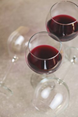 Masada iki kırmızı şarap bardağı ve iki boş şarap bardağı var. Yaratıcı sanat konsepti, uzun bardaklarda kırmızı şarap. Alkolik içecek..