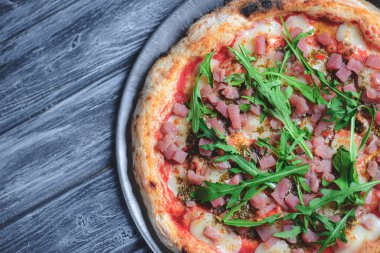 Somon balığı, peynir ve rustik gri ahşap arka planda taze roka ile pizza. İtalyan mutfağı konsepti, geleneksel pizza tarifi.