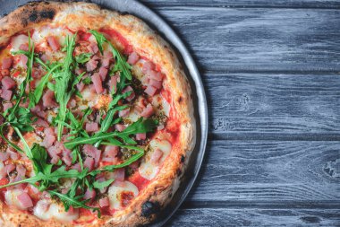 Somon balığı, peynir ve rustik gri ahşap arka planda taze roka ile pizza. İtalyan mutfağı kavramı