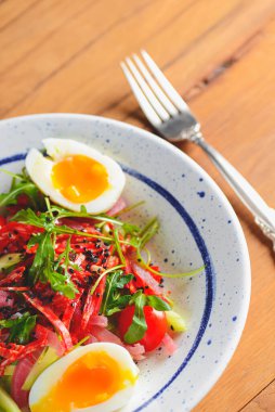 Sebzeli ton balığı salatası, haşlanmış yumurta, ahşap zemin üzerinde kiraz domatesleri ve baharatlar. İtalyan mutfağı kavramı.