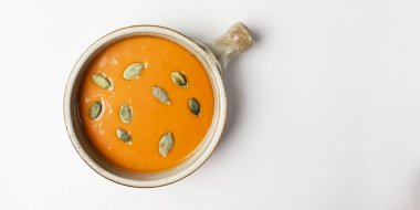 Beyaz arka planda servis edilen kabak tohumlu kabak çorbası. Geleneksel tarif, kremalı çorba izole edilmiş. Boşluk afişini kopyala.