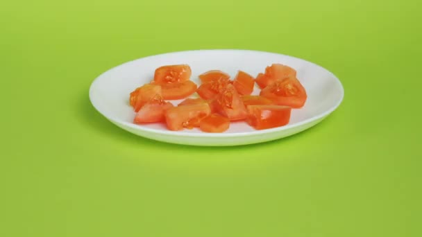 在明亮的绿色背景上切下白盘上的红番茄素 切新鲜蔬菜烹调 凯撒沙拉传统配方的配料 — 图库视频影像