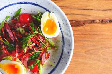 Sebzeli ton balığı salatası, haşlanmış yumurta, ahşap zemin üzerinde kiraz domatesleri ve baharatlar. İtalyan mutfağı kavramı.