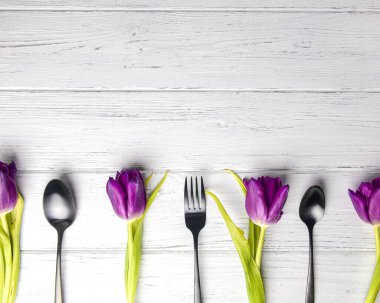 Taze laleler ve çatal bıçak takımları. Uzay afişini kopyala. Beyaz rustik ahşap arkaplan.