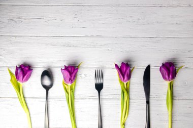 Taze laleler ve çatal bıçak takımları. Uzay afişini kopyala. Beyaz rustik ahşap arkaplan.