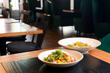 Taze mantarlı karabuğday köftesi ve peynirli sebze salatası, taze romatolar ve restoranda tbalede servis edilen beyaz tabakta salatalık. Sağlıklı yeme kavramı.