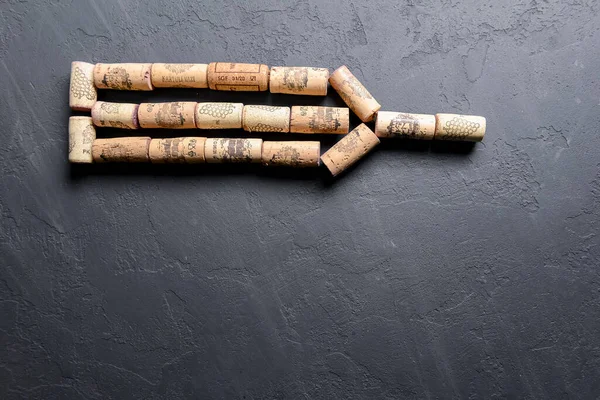 Collection set of wine corks over black background. Art concept, creative idea. Corks in form of a bottle.