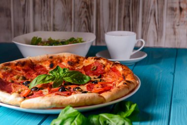 Salamlı ve siyah zeytinli taze İtalyan pizzası. Geleneksel İtalyan pizza tarifi, İtalyan mutfağı. Pizzaya yaklaş. Fast food, abur cubur kavramı.