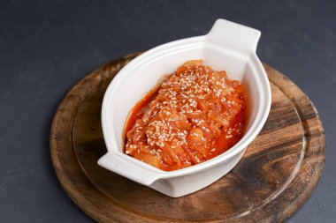 Fırınlanmış sebze güveci ve balık. Siyah arka planda beyaz bir tencerede hizmet vermiş. Lezzetli mevsimlik akşam yemeği, sonbahar yemeği.