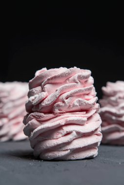 Marshmallow - karanlık bir arka planda zephyr. Siyah yerine çilek tadı olan pembe kabarık şekerleme. Kapat ve Zephyr 'e odaklan..