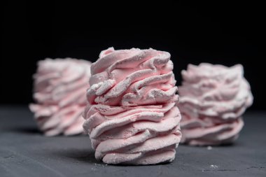 Marshmallow - karanlık bir arka planda zephyr. Siyah yerine çilek tadı olan pembe kabarık şekerleme. Kapat ve Zephyr 'e odaklan..