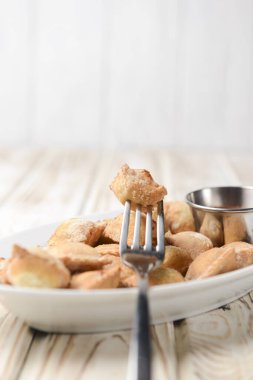 Etle doldurulmuş kızarmış hamur köftesi ve beyaz tabakta domates sosuyla servis edilmiş. Pelmeni tavada kızartılmış, Ukrayna mutfağı ve Rus mutfağı kavramı. Kırsal ahşap arka planda.