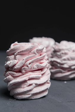 Marshmallow - karanlık bir arka planda zephyr. Siyah yerine çilek tadı olan pembe kabarık şekerleme. Kapat ve Zephyr 'e odaklan..