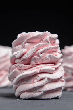 Marshmallow - karanlık bir arka planda zephyr. Siyah yerine çilek tadı olan pembe kabarık şekerleme. Kapat ve Zephyr 'e odaklan..