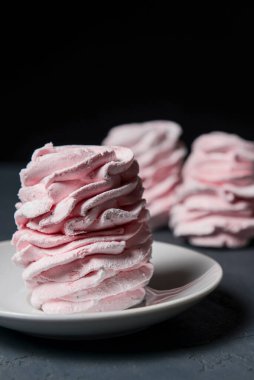 Marshmallow - karanlık bir arka planda zephyr. Siyah yerine çilek tadı olan pembe kabarık şekerleme. Kapat ve Zephyr 'e odaklan..