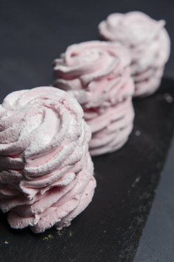 Marshmallow - karanlık bir arka planda zephyr. Siyah yerine çilek tadı olan pembe kabarık şekerleme. Kapat ve Zephyr 'e odaklan..