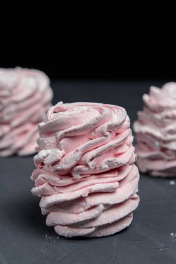 Marshmallow - karanlık bir arka planda zephyr. Siyah yerine çilek tadı olan pembe kabarık şekerleme. Kapat ve Zephyr 'e odaklan..