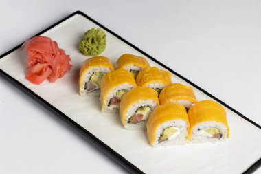 Beyaz arka planda işlenmiş peynirli suşi ruloları, Amerikan peyniri, avokado, ton balığı ve krem peynir. Philadelphia suşisi. Suşi menüsü