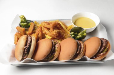 Beyaz arka planda servis edilen tepside dört hamburger ve kızarmış tavuk. Abur cubur, arkadaşlarla parti konsepti..