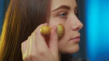 Genç ve çekici bir kadın makyaj yapıyor. Güzellik endüstrisi konsepti, beyaz bir kadının hazırlanması. Sabahları hazırlanıyor, gülümsüyor güzel kız makyaj yapıyor, yüzüne makyaj yapıyor..