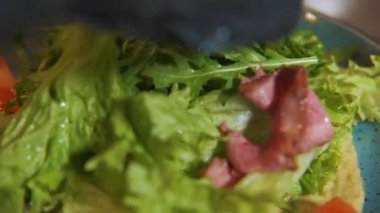 Sebzeli taze salata ve tabakta biftek, salata yapma süreci. Mutfakta çalışan bir aşçı. Restoran kompleksi. Malzemeleri tabağa koy: domates, soğan, roka..