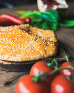 Khachapuri peynirle birlikte, ahşap bir tahtanın üzerinde, ahşap bir masanın üzerinde servis ediliyor. Geleneksel Gürcü mutfağı konsepti. Seçici odak, bulanık arkaplan.