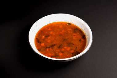 Borş, Ukrayna pancar çorbası, siyah arka planda beyaz kase. Geleneksel Ukrayna mutfağı konsepti, sağlıklı yemek..