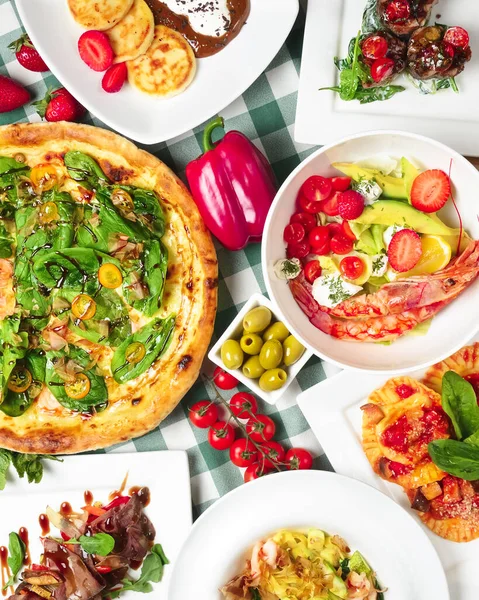 İtalyan yemeği pişti ve masada yeşil ekose masa örtüsüyle servis edildi. Karidesli makarna, carpaccio salatası, ıspanaklı pizza, yeşil zeytin ve vişneli domates. İtalyan konsepti, düz yatak.