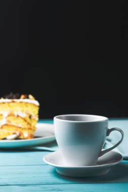 Bir fincanda kapuçino kahvesi ve şam fıstıklı kek, fındıklı kek, siyah arka planda. Kahve zamanı, tatlı tatlı.