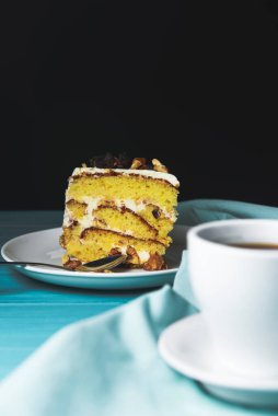 Bir fincanda kapuçino kahvesi ve şam fıstıklı kek, fındıklı kek, siyah arka planda. Kahve zamanı, tatlı tatlı.