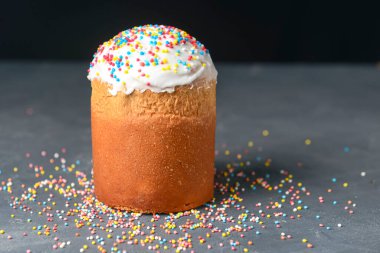 Paskalya kompozisyonu, ortodoks tatlı ekmek, kulich ve koyu siyah arkaplan üzerine serpiştirilmiş. Fotokopi alanı olan Paskalya tatili konsepti. Seçici odaklanma, bulanık arkaplan. Tatil kutlaması.