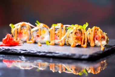 Maki Futomaki suşi rulosu, yılan balığı, yumurta, unagi sosu. Suşi menüsü. Japon yemeği. Yakın çekim, seçici odaklanma, bulanık bir arka plan. Geleneksel tarif.