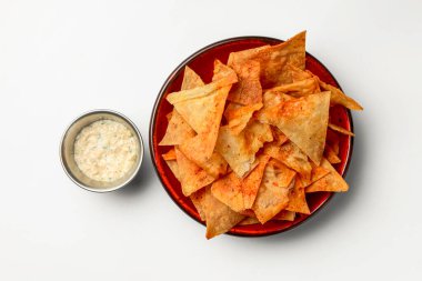 Nachos cipsleri beyaz arka planda kasede. Beyaz üzerine izole edilmiş sıcak baharatlı tortilla cipsi. Fast food, abur cubur konsepti, bira çerezi.