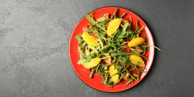 Kırmızı tabakta servis edilen lezzetli karışık sebze ve meyve salatası. Sağlıklı beslenme konsepti, taze sebze salatası.