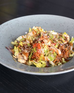 Asya tavası kızartması, koyu ahşap bir masada servis edilir. Asya mutfağı konsepti, geleneksel tarif. Sağlıklı beslenme.